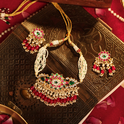 Decorative necklace and earrings on an ornate box with a red background